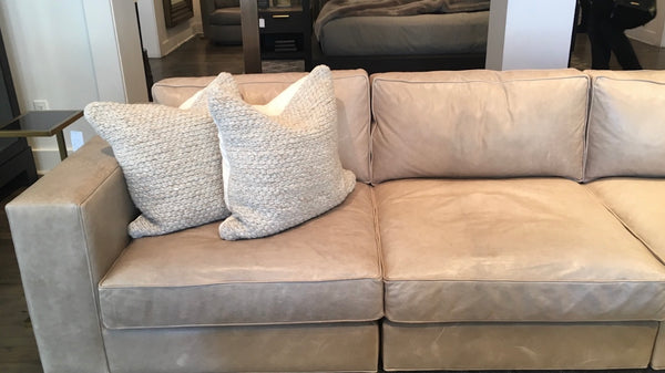 Tan Leather Sofa with two throw pillows neatly arranged in the left corner